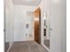 View of a bathroom through an open door in the hallway with a toilet, tub, and white walls at 755 S Alton Way # 8D, Denver, CO 80247