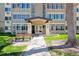 Condo building entrance with a walkway, bench, and well-maintained landscaping at 755 S Alton Way # 8D, Denver, CO 80247