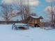 Snowy backyard with shed, trampoline, and sandbox at 1466 Elmwood Ln, Denver, CO 80221