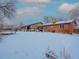 Brick home with snowy backyard and patio furniture at 1466 Elmwood Ln, Denver, CO 80221