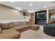 Finished basement with sectional sofa, wet bar, and large TV at 1466 Elmwood Ln, Denver, CO 80221