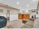 Finished basement with sectional sofa, wet bar, and large TV at 1466 Elmwood Ln, Denver, CO 80221