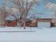 Ranch style home with a snow covered yard and attached garage at 1466 Elmwood Ln, Denver, CO 80221