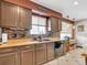 Kitchen with dark brown cabinets, tile backsplash, and stainless steel appliances at 1466 Elmwood Ln, Denver, CO 80221