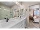 Modern bathroom with double sinks, walk-in shower, and neutral tones at 10105 Morrison Rd, Lakewood, CO 80227