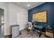 Home office with an accent wall, a modern desk, rolling chair, and a mini fridge at 10105 Morrison Rd, Lakewood, CO 80227