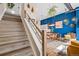 View of living room from stairs featuring accent wall and modern, open concept design at 10105 Morrison Rd, Lakewood, CO 80227