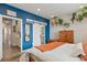 Bright bedroom showcasing barn door access to the en suite bath, wood floors and designer color accent wall at 10105 Morrison Rd, Lakewood, CO 80227