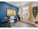 Well-lit home office with a desk, stylish curtains, and bold blue accent wall at 10105 Morrison Rd, Lakewood, CO 80227