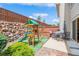 Backyard features a wooden playset, patio with outdoor dining, and rock landscaping at 155 Xenon St # 33, Denver, CO 80228