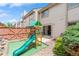 Backyard features a wooden playset, sliding glass door access to home, and rock landscaping at 155 Xenon St # 33, Denver, CO 80228