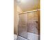 Bathroom with a sliding glass shower door and tiled walls around the tub at 155 Xenon St # 33, Denver, CO 80228