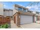 Townhome showcasing a two-car garage, brick accents, and private side entrance at 155 Xenon St # 33, Denver, CO 80228