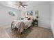 Well-lit bedroom with ceiling fan, two windows, cozy bed, and decorative wall art at 1195 S Kendall St, Lakewood, CO 80232