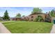 Well-maintained ranch-style home with a green lawn, tidy landscaping, and inviting curb appeal at 1195 S Kendall St, Lakewood, CO 80232