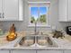 Close-up of a kitchen sink with granite countertops, a window view, and stainless steel features at 1195 S Kendall St, Lakewood, CO 80232