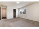Spacious bedroom features neutral carpet, a window, a closet, and an open doorway at 7700 W Glasgow Pl # 24C, Littleton, CO 80128