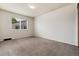 A bright bedroom featuring neutral carpet and paint, with a large window at 7700 W Glasgow Pl # 24C, Littleton, CO 80128