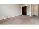 Bedroom featuring neutral carpet, a closet, and an open doorway at 7700 W Glasgow Pl # 24C, Littleton, CO 80128