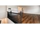 Open-concept living space with sleek floors, railing and seamless flow to the kitchen area at 7700 W Glasgow Pl # 24C, Littleton, CO 80128