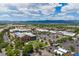 Aerial view of bustling shopping center with a lake in the distance, surrounded by lush greenery at 9442 W Walden Ave, Littleton, CO 80128