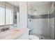 Updated bathroom with glass enclosed shower, rock floor, and a stone countertop sink at 9442 W Walden Ave, Littleton, CO 80128