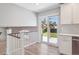 Bright kitchen area featuring white cabinets, sliding glass doors and view of backyard patio at 9442 W Walden Ave, Littleton, CO 80128