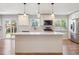 Bright kitchen featuring white cabinets, an island, stainless steel appliances, and sliding glass doors at 9442 W Walden Ave, Littleton, CO 80128