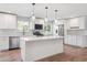 Open kitchen with white cabinets, stainless steel appliances, and a center island with pendant lighting at 9442 W Walden Ave, Littleton, CO 80128