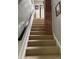 Carpeted staircase with a black handrail and a brick accent wall leading to the upper level at 3098 W 39Th Ave, Denver, CO 80211