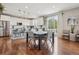 Open dining area with hardwood floors, pendant lighting, and a view of the modern kitchen at 5362 E 140Th Pl, Thornton, CO 80602