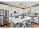 Bright kitchen features stainless appliances, white cabinetry, granite countertops, and a large center island with seating at 5362 E 140Th Pl, Thornton, CO 80602