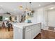 Open concept kitchen featuring white cabinets, an island with seating, and views of the dining and living room at 5362 E 140Th Pl, Thornton, CO 80602