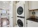 Laundry room featuring a stacked washer and dryer, cabinetry, and a view of the kitchen at 5362 E 140Th Pl, Thornton, CO 80602