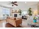 Bright living room with a fireplace, ceiling fan, hardwood floors, and comfortable seating at 5362 E 140Th Pl, Thornton, CO 80602