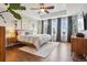 Main bedroom with tray ceiling, ceiling fan, hardwood floors, and many windows with beautiful curtains at 5362 E 140Th Pl, Thornton, CO 80602