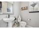 Stylish powder room with a modern vanity, decorative mirror, and floating shelves by the window at 5362 E 140Th Pl, Thornton, CO 80602
