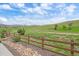 Scenic backyard view featuring a wooden fence, rocks, and lush greenery at 9433 Torrey Way, Arvada, CO 80007