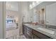 Bathroom with double sinks, granite countertops, and a door to the bedroom at 9433 Torrey Way, Arvada, CO 80007