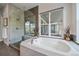Bathroom featuring a walk-in shower, soaking tub, and a large window at 9433 Torrey Way, Arvada, CO 80007