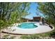 A large community pool with ample seating, surrounded by lush landscaping and mature trees at 9433 Torrey Way, Arvada, CO 80007