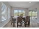 Bright dining room featuring a modern table and chairs, with large windows overlooking the yard at 9433 Torrey Way, Arvada, CO 80007