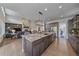 Open concept kitchen featuring a large granite island, stainless steel appliances, and hardwood floors at 9433 Torrey Way, Arvada, CO 80007