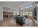 Open-concept living room with kitchen and dining area, featuring hardwood floors and large windows at 9433 Torrey Way, Arvada, CO 80007