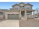 Charming two-story home with stone accents, a covered porch, and a two-car garage on a sunny day at 24704 E Pacific Pl, Aurora, CO 80018