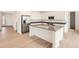 Modern kitchen with a large island, stainless steel appliances, and white cabinets at 24704 E Pacific Pl, Aurora, CO 80018