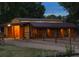 Exterior of the barn at dusk, featuring wooden stalls, a metal roof, and a rustic fence with trees in background at 7130 Independence St, Arvada, CO 80004