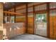 Inside barn stall showing wooden paneling, metal bars, and open doorway to a paddock, showing country property at 7130 Independence St, Arvada, CO 80004