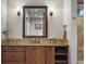 Stylish bathroom features a wood vanity, decorative backsplash, and modern fixtures and lighting at 7130 Independence St, Arvada, CO 80004