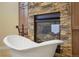 Luxurious bathroom featuring a freestanding tub and a fireplace with stone surround, creating a relaxing oasis at 7130 Independence St, Arvada, CO 80004